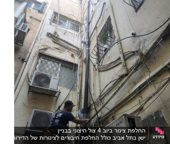 אינסטלטור עובד על צינור חיצוני בבניין גבוה